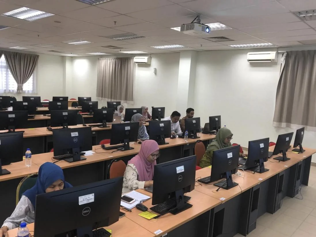 Participants working through AI exercises in a Muntada training lab